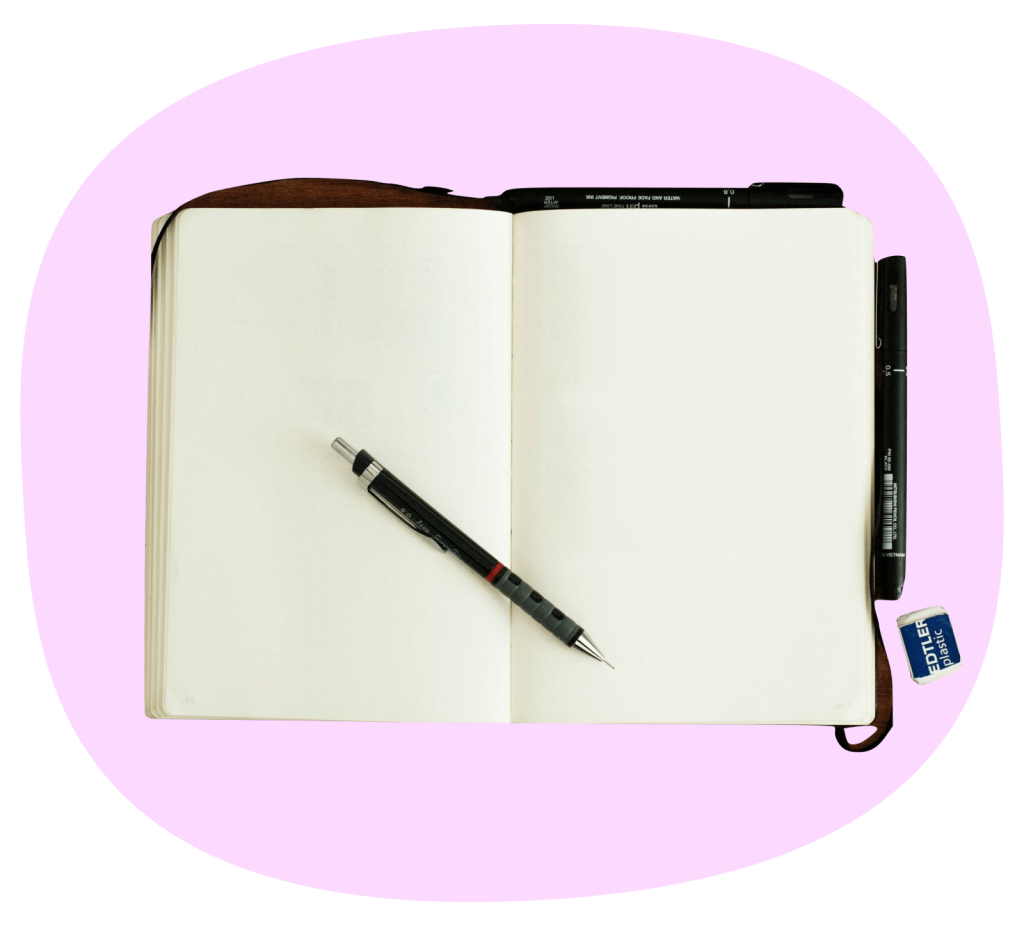 open blank notebook with a pen on a pink background, representing hands-on project-based learning