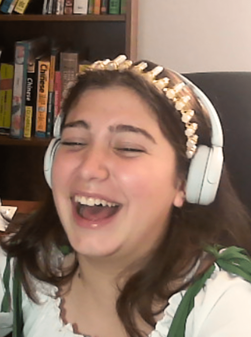 Prisma learner laughing during an online homeschool class wearing headphones