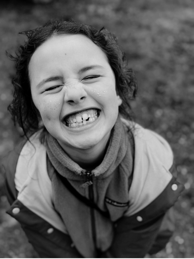 young Prisma lower school student laughing joyfully in black and white portrait