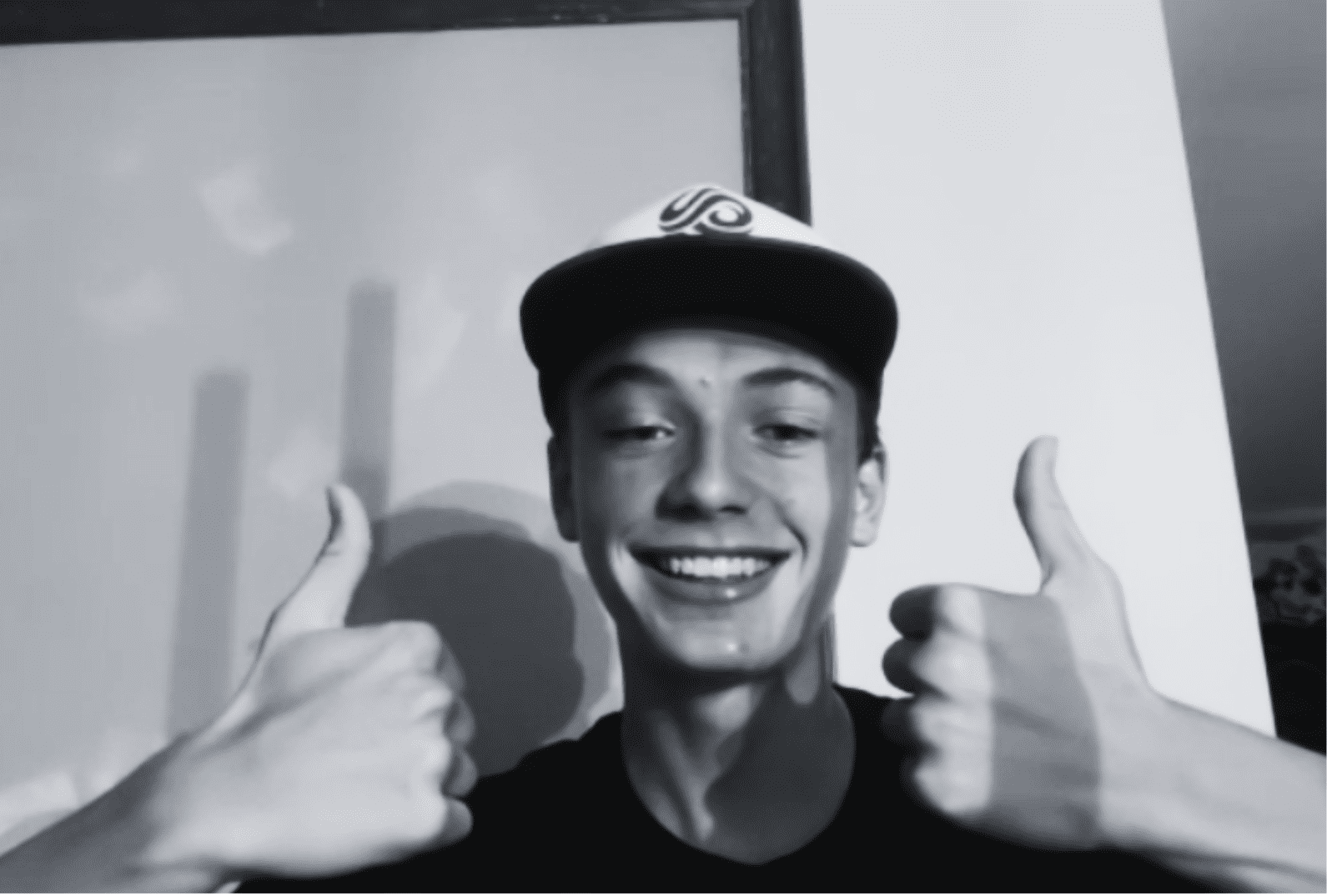 smiling Prisma student giving two thumbs up in black and white