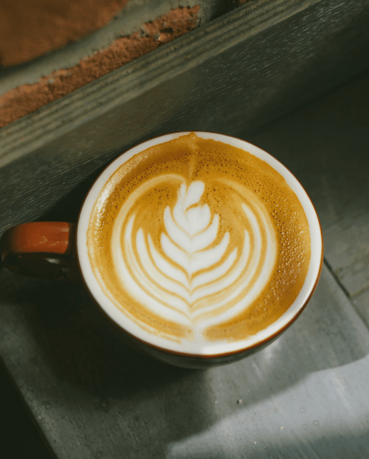 latte with leaf art in a ceramic mug