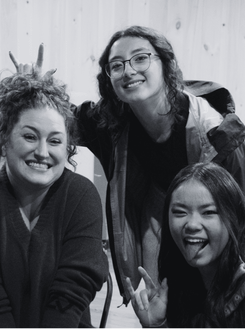 Prisma coach and two high school homeschool students smiling and laughing together in black and white photo