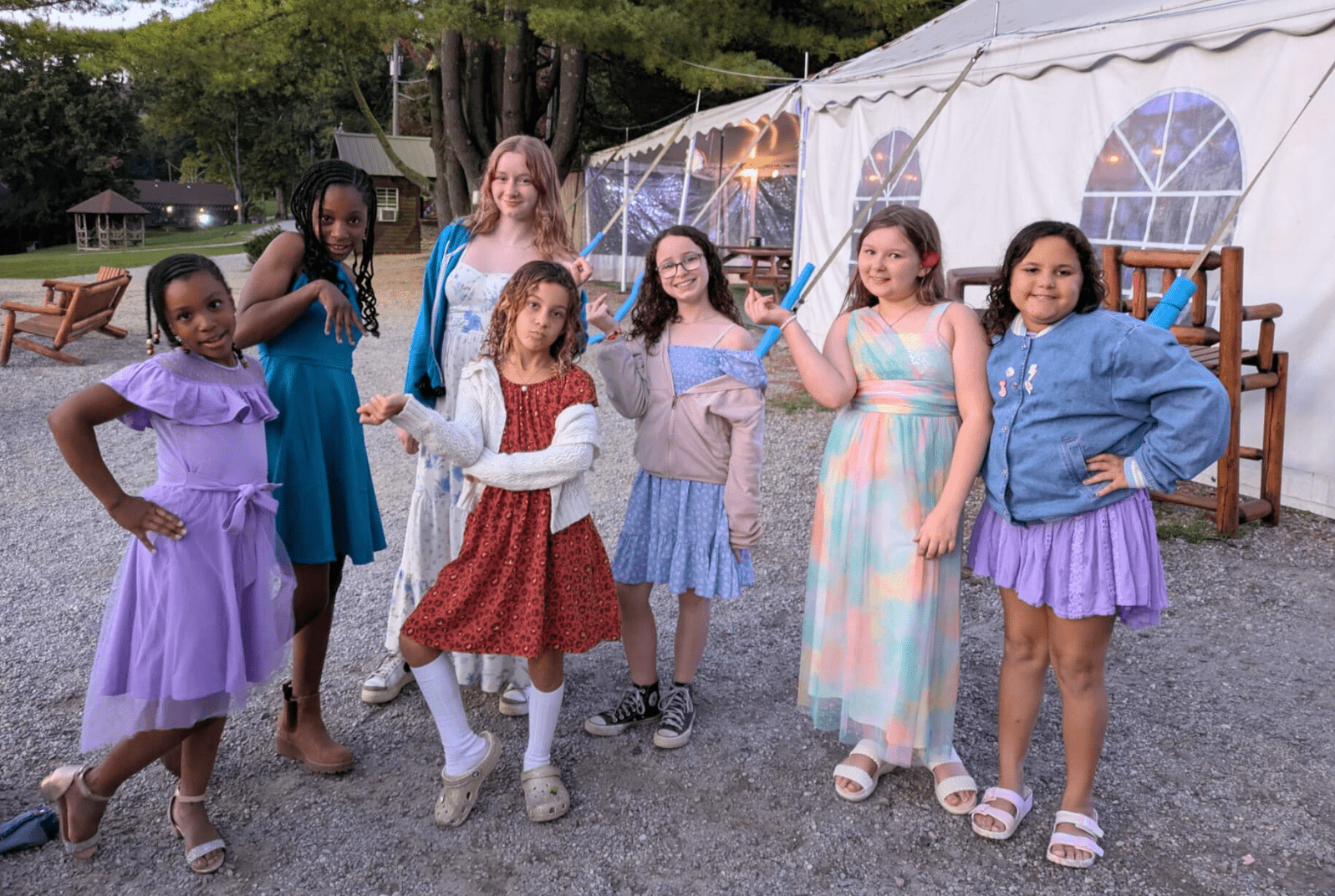 group of Prisma students in colorful dresses posing outdoors at an event