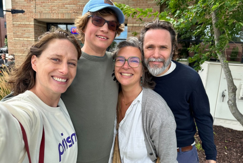 Prisma family selfie with a student wearing a Prisma cap at an outdoor meetup