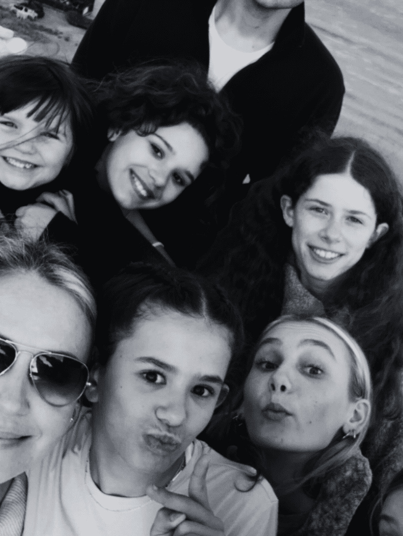 group of smiling Prisma students taking a black-and-white friendship selfie together