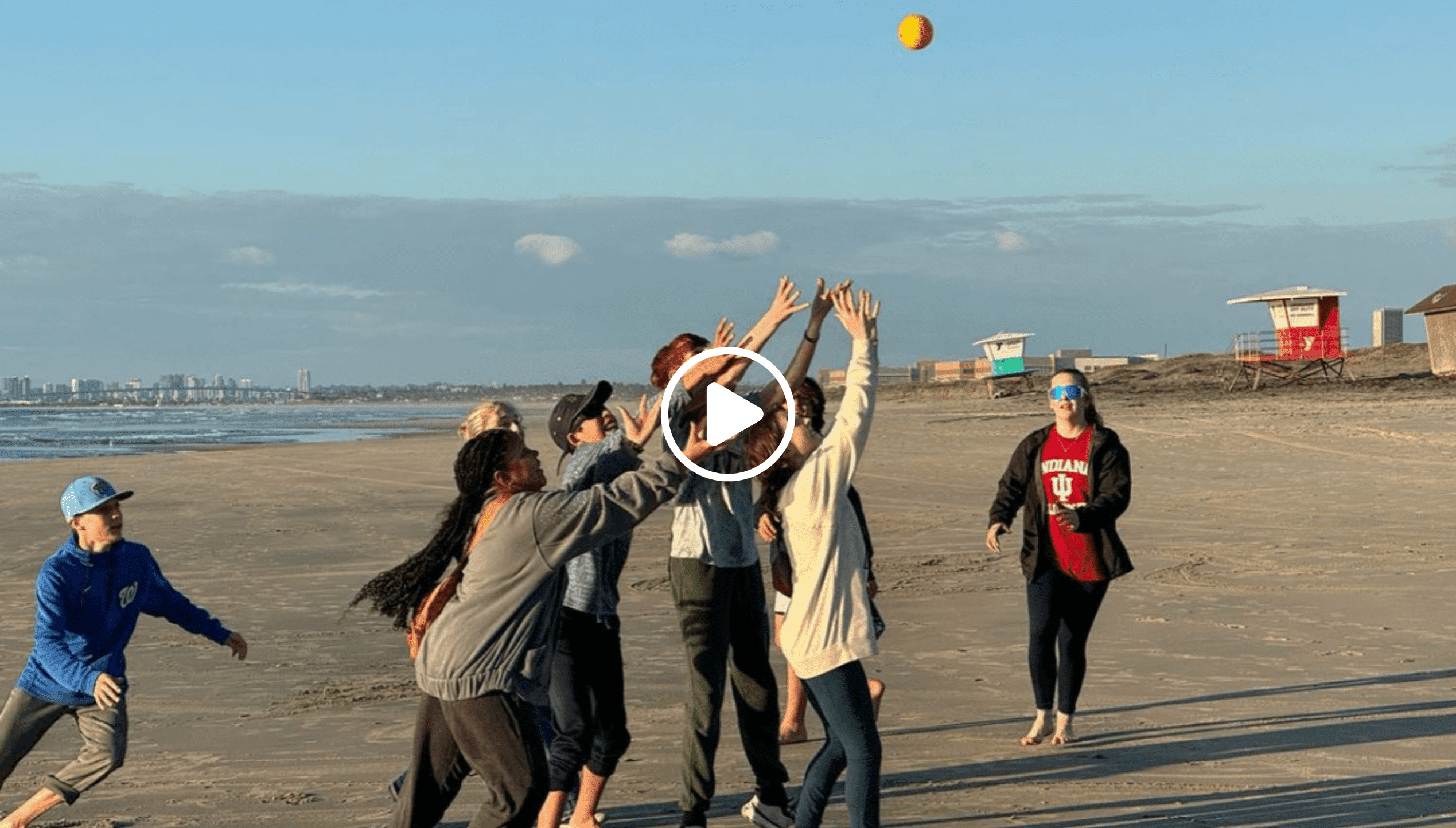 Prisma learners playing a ball game together on a beach during an Endeavor trip