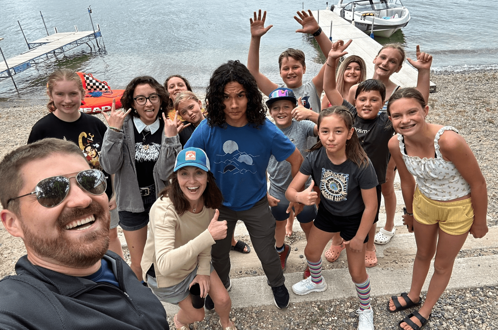 Prisma middle school students and coaches in a group selfie by a lake