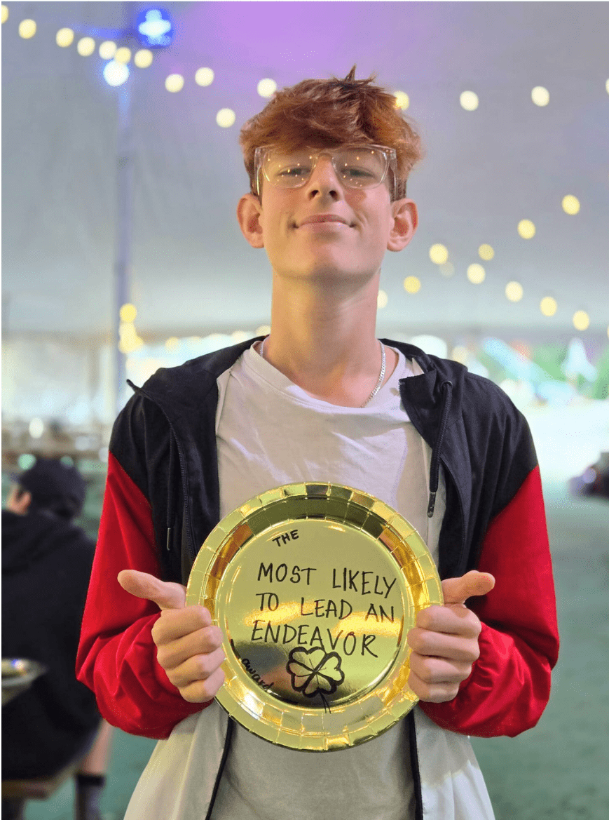 Prisma student holding a gold plate award for most likely to lead an endeavor