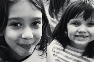 two young Prisma lower school learners smiling together in black and white close-up